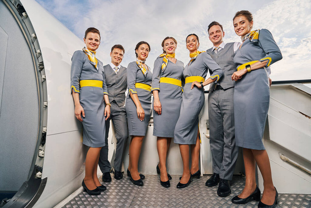Siedmiu stewardesów stojących na schodach - Zdjęcie, obraz
