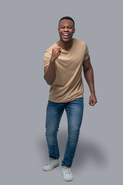 Studio picture of dark-skinned man in a beige tshirt - Foto, Imagen