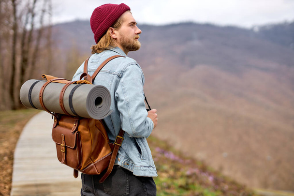 male traveler walking, going to explore wild environment at spring, side view - Valokuva, kuva