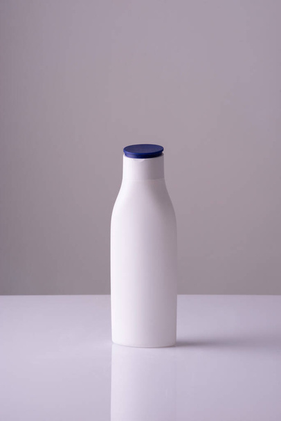 white bottle of cream on a white-gray background background. Skin care cream, anti-tan. - Fotoğraf, Görsel