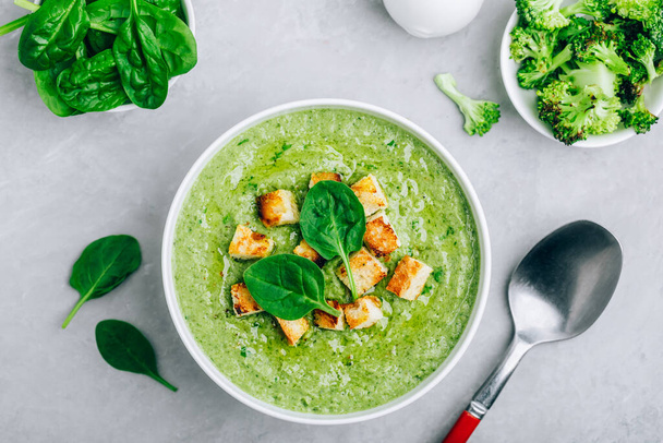 Green Cream Soup. Spinach broccoli creamy soup with croutons on gray stone background. Top view with copy space. - Valokuva, kuva