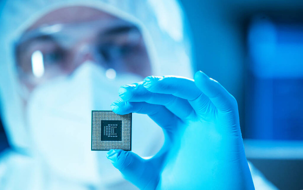 The scientist works in a modern scientific laboratory for the research and development of microelectronics and processors. Microprocessor manufacturing worker uses computer technology and equipment. - Фото, изображение