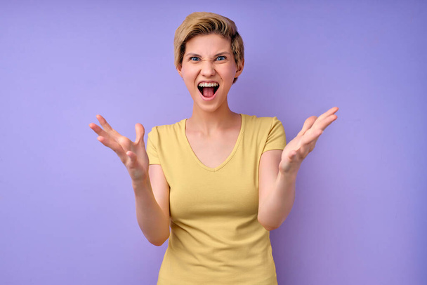 woman scream isolated in studio on purple background, female spreading arms, irritated - Foto, Bild