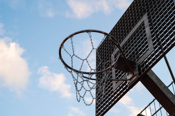 Venkovní kovová ulice basketbal obruč s modrou oblohou v pozadí. - Fotografie, Obrázek