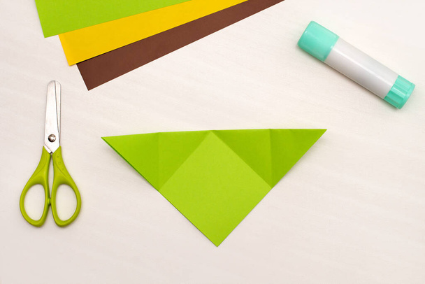 Instrucciones paso a paso para hacer marcadores de esquina del árbol de Navidad. Bricolaje. Ideas creativas de origami para niños. Vista superior plano laico. Etapa 2 - Foto, Imagen