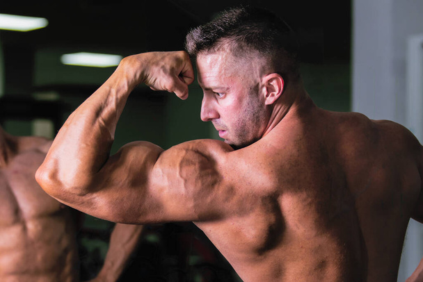 Strong bodybuilder man showing his big bicep muscles. - Zdjęcie, obraz