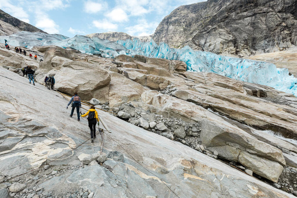 Turistas estão subindo a superfície de rocha da geleira Jostedal - Foto, Imagem