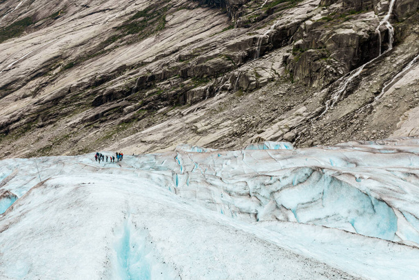 Turyści stoją na śnieżnej powierzchni lodowca Jostedal - Zdjęcie, obraz