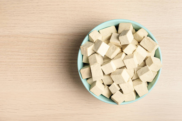 Delicious tofu on wooden table, top view. Space for text - Fotó, kép