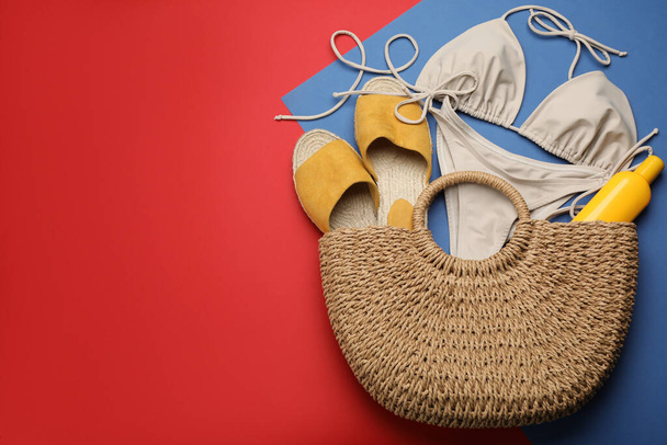 Stylish bag with beach accessories on color background, flat lay. Space for text - Foto, immagini