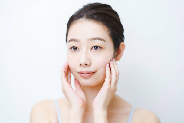 Asiatische junge Frau überprüft den Zustand ihrer Haut - Foto, Bild