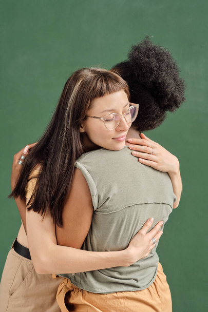 Dwie młode międzykulturowe kobiety obejmujące się nawzajem - Zdjęcie, obraz