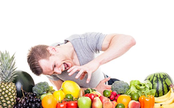 Crazy athletic man with fruits and vegetables, isolated on white - Photo, Image