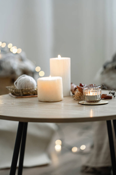 Schöne brennende Kerzen im Inneren eines Zimmers im skandinavischen Stil. - Foto, Bild