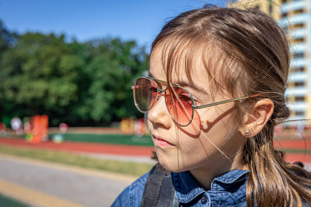Маленька дівчинка, студентка початкової школи в сонцезахисних окулярах, відкритий крупним планом
. - Фото, зображення
