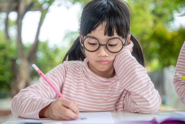 Kisázsiai lány könyvet ír az osztályteremben  - Fotó, kép