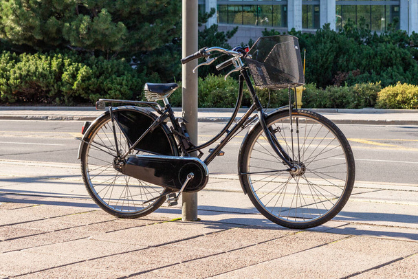Ottawa, Canada - August 2, 2021: The bike parked next to pole, secured with locking device on the street in downtown of Ottawa, Canada. Healthy lifestyle and environmentally friendly transport concept. - Foto, Imagem