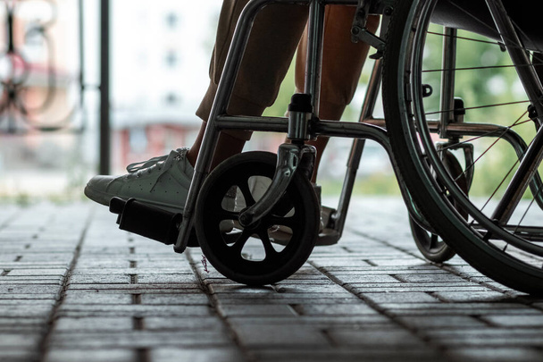 The girl is sitting in a wheelchair, legs close-up. The concept of bias towards disabled people, depression, disability - 写真・画像