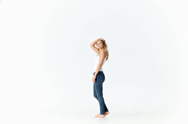 woman barefoot in jeans movement positive emotions light background - Φωτογραφία, εικόνα