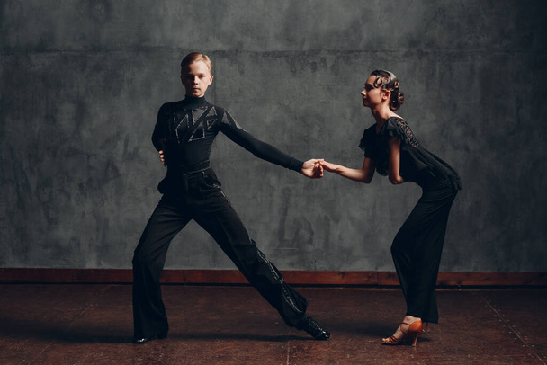 Couple young man and woman in black dress dancing in ballroom dance rumba. - Photo, Image