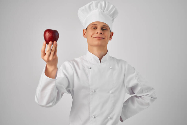 Cheerful chef with apple in hands cooking work light background - Φωτογραφία, εικόνα