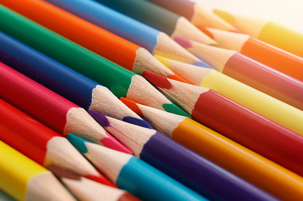 Kolorowe naostrzone ołówki leżą w rzędzie z bliska. Solidne abstrakcyjne tło drewnianych wielobarwnych ołówków. - Zdjęcie, obraz