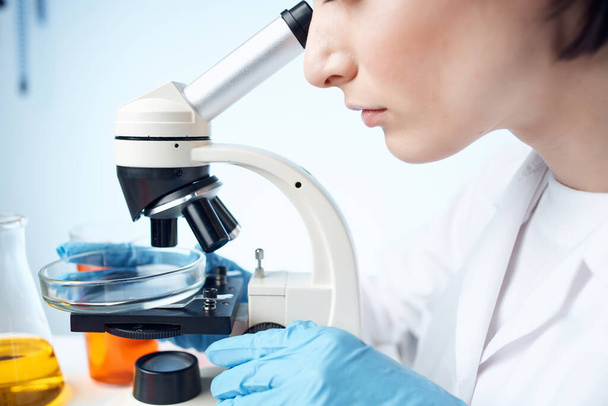 Naispuolinen laboratorioassistentti tutkimassa mikroskooppitutkimusta - Valokuva, kuva