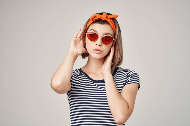 mujer bonita en gafas de sol con un vendaje en su cabeza estilo moderno fondo de luz - Foto, imagen