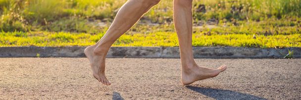 A man runner is engaged in jogging on the asphalt without shoes, without sneakers, for health BANNER, LONG FORMAT - Φωτογραφία, εικόνα