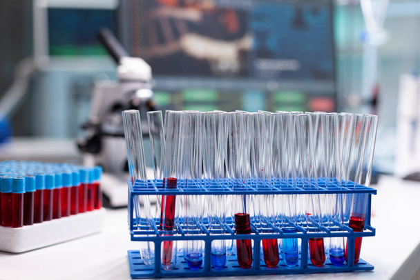 Медицинская пробирка с образцом крови, стоящей на столе во время фармацевтического осмотра - Фото, изображение