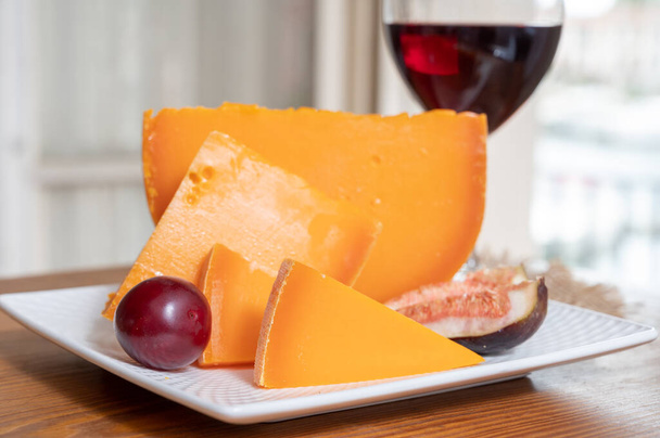 Cheese collection, French yellow cheese mimolette made from cow milk served with fresh figs and red wine - Photo, Image