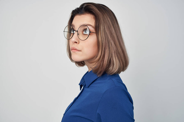 elegant woman with glasses in blue shirt fashion light background - Photo, Image