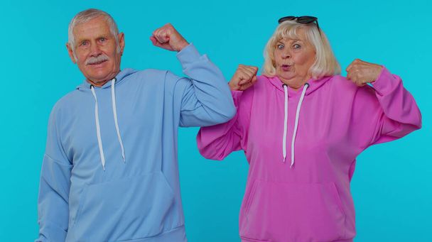 Senior man woman grandparents showing biceps feeling power strength to fight for rights, success win - Photo, Image