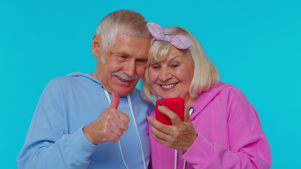 Ευτυχισμένο ζευγάρι ηλικιωμένων οι παππούδες χρησιμοποιούν το κινητό τηλέφωνο γιορτάζουν ανακάλυψε μεγάλη νίκη ειδήσεις - Φωτογραφία, εικόνα