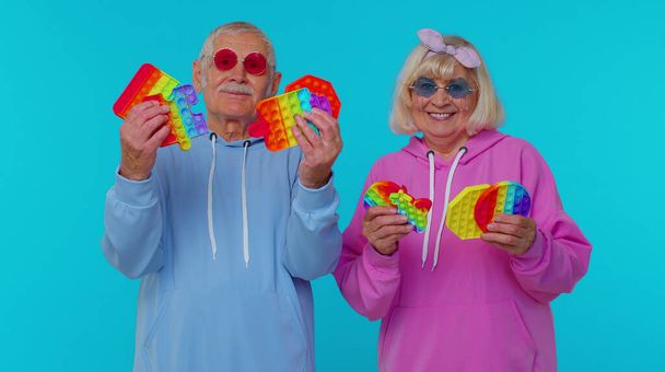 sonriendo viejo abuelo abuela madura celebración anti-estrés pantalla táctil empuje pop es juguete popular - Foto, Imagen