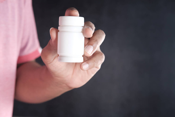 young man hand holding medicine pill container  - 写真・画像