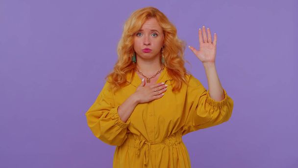 誠実な責任ある赤毛の女の子が誓いを立てるために手を挙げて正直になり真実を話すことを約束する - 写真・画像