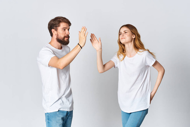 άνδρας και γυναίκα σε λευκό t-shirts στούντιο μόδας ποζάροντας διασκεδαστικό φως φόντο - Φωτογραφία, εικόνα