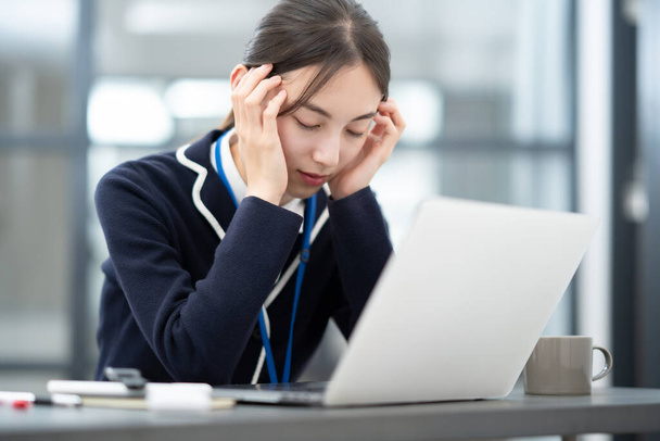 Asian woman suffering from a headache at work - Photo, Image