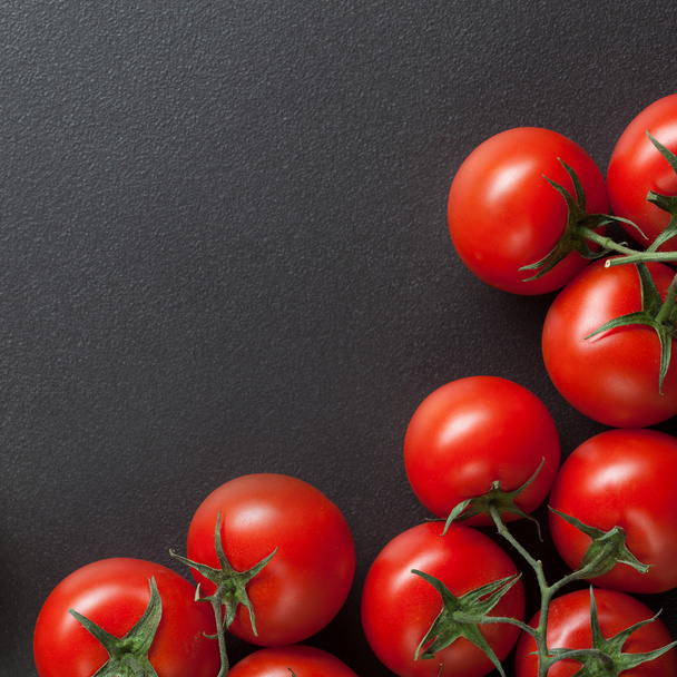 red tomatoes on blac - Фото, изображение