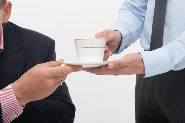 Assistant brings coffee cup to senior manager - Photo, Image