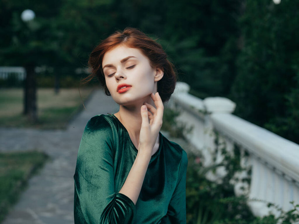 csinos nő zöld ruhában piros ajkak báj természet séta divat - Fotó, kép