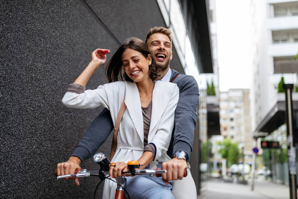 Portrait of happy young couple in love riding a bicycle and having fun together outdoor - Foto, Imagem