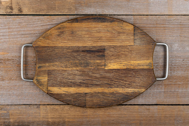 Empty cutting board on a wooden table. Space for text. Top View. - Фото, зображення