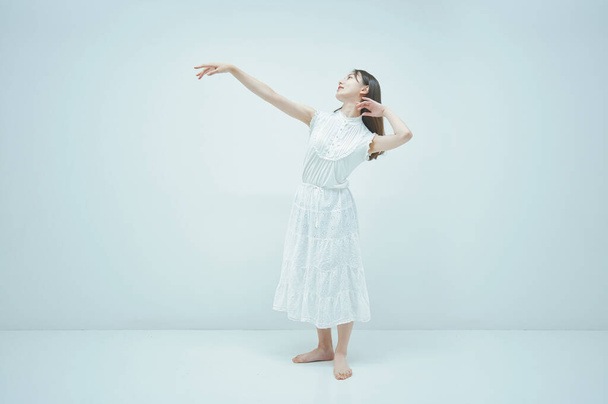 Asiatische junge Frau tanzt anmutig und weißen Hintergrund - Foto, Bild