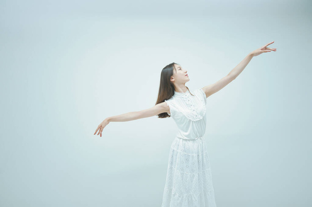 アジアの若い女性が優雅に踊ると白の背景 - 写真・画像