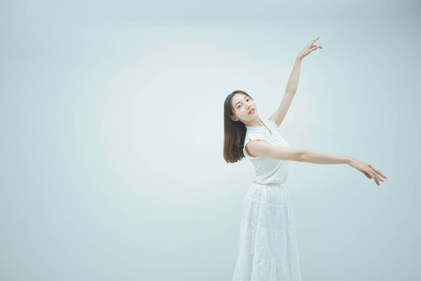 aziatische jong vrouw dansen sierlijk en wit achtergrond - Foto, afbeelding