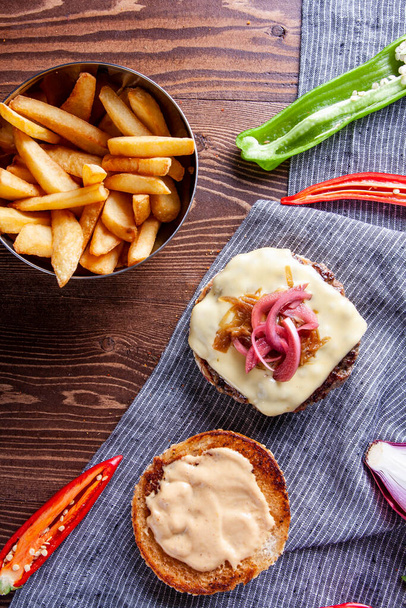 Сирний бургер, карамелізована цибуля та картопля фрі
. - Фото, зображення