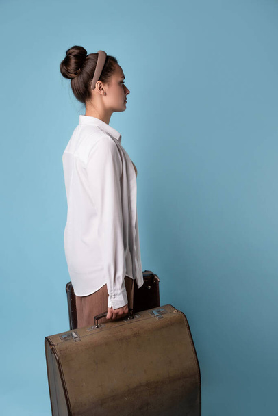 cute young woman in summer pants and white shirt holds a briefcase in her hands - Foto, Bild