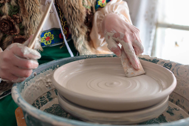 primer plano de las manos del alfarero en el trabajo, creando un plato individual - Foto, Imagen